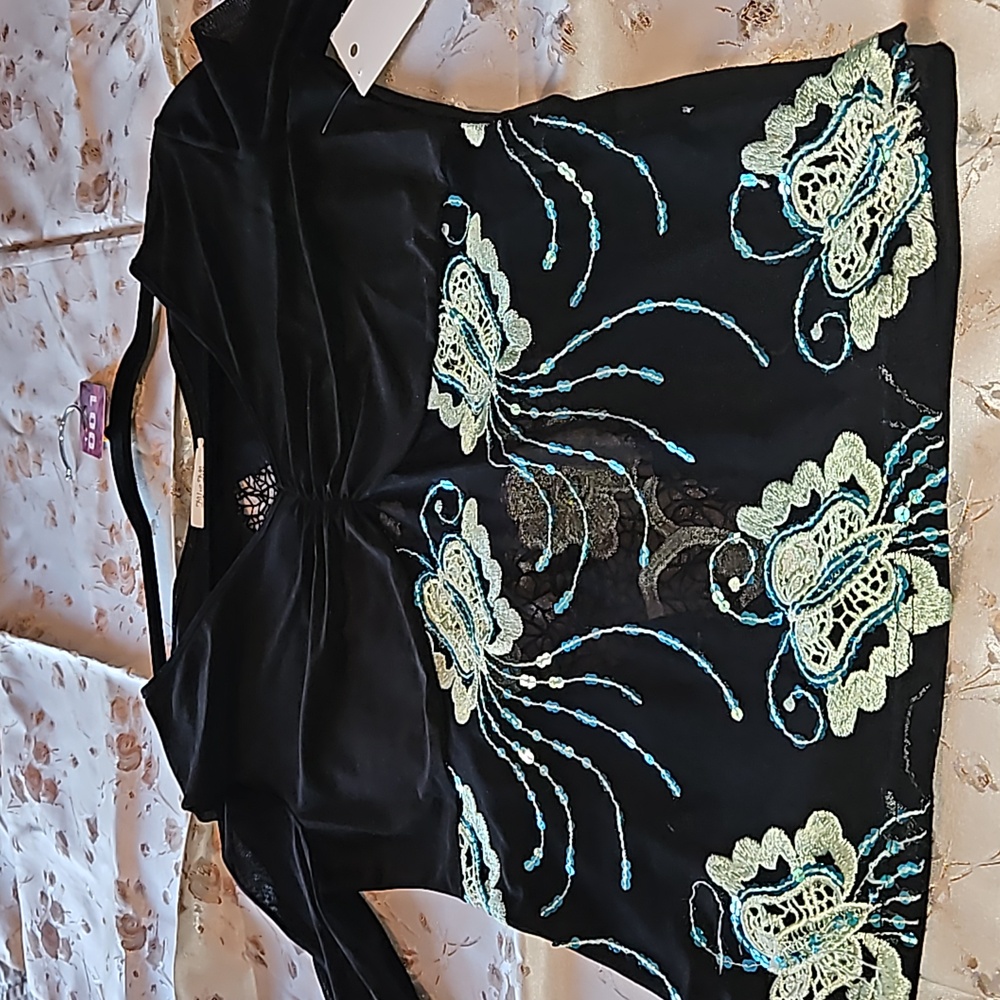 Black blouse w turquoise sequin design. Sheer arms.